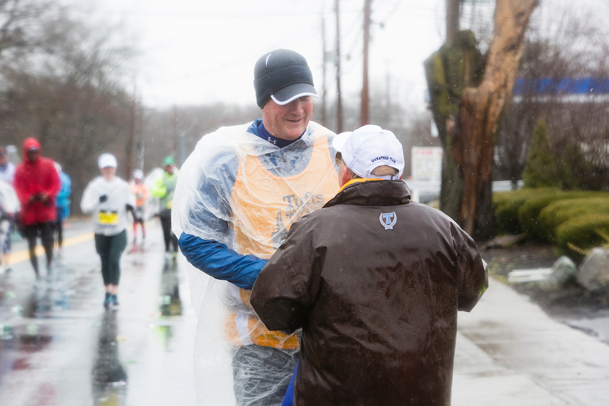 Eric Johnson gets moral support, and a sandwich, from Tufts Marathon Team Coach Don Megerle. Photo: Anna Miller